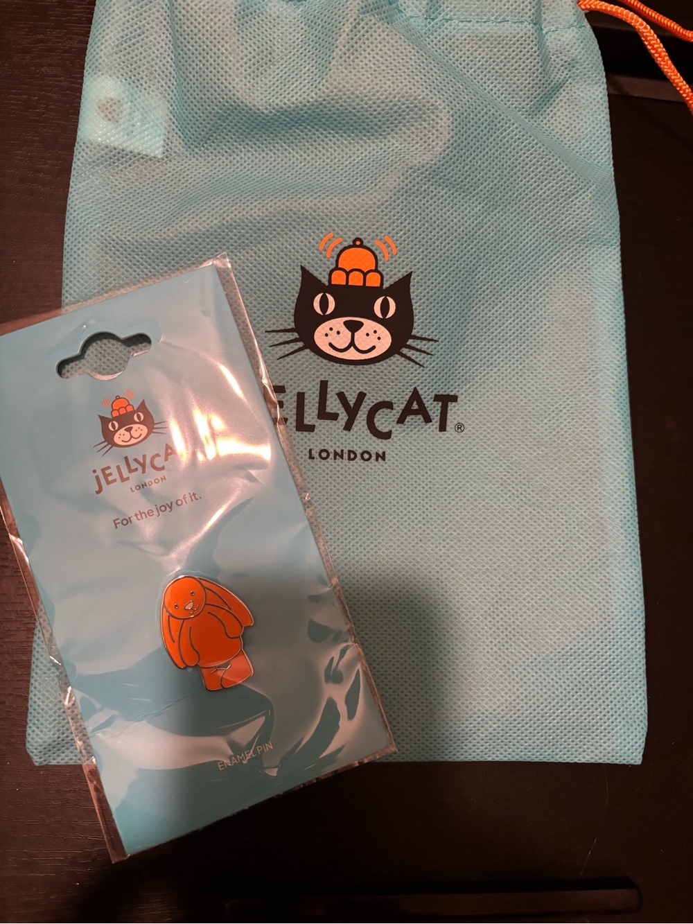 Jellycat light blue drawstring pouch with orange bunny enamel pin
